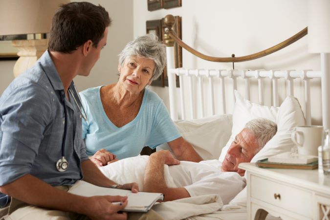 médecin rend visite à un homme âgé mourant à la maison