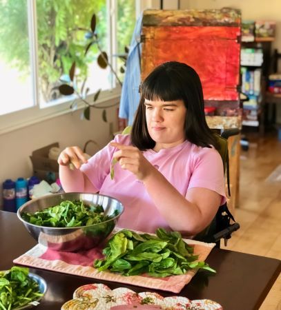 A young woman makes a salad.