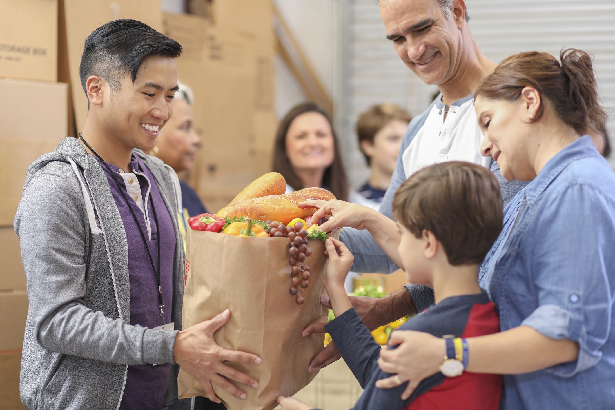 A family receiving a bag of groceries.