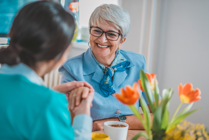 Health worker with a woman and flowers.