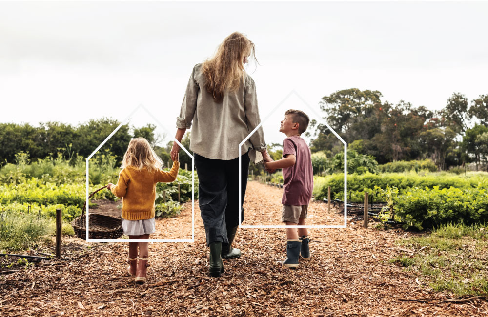 Woman walking and holding hands with 2 children.