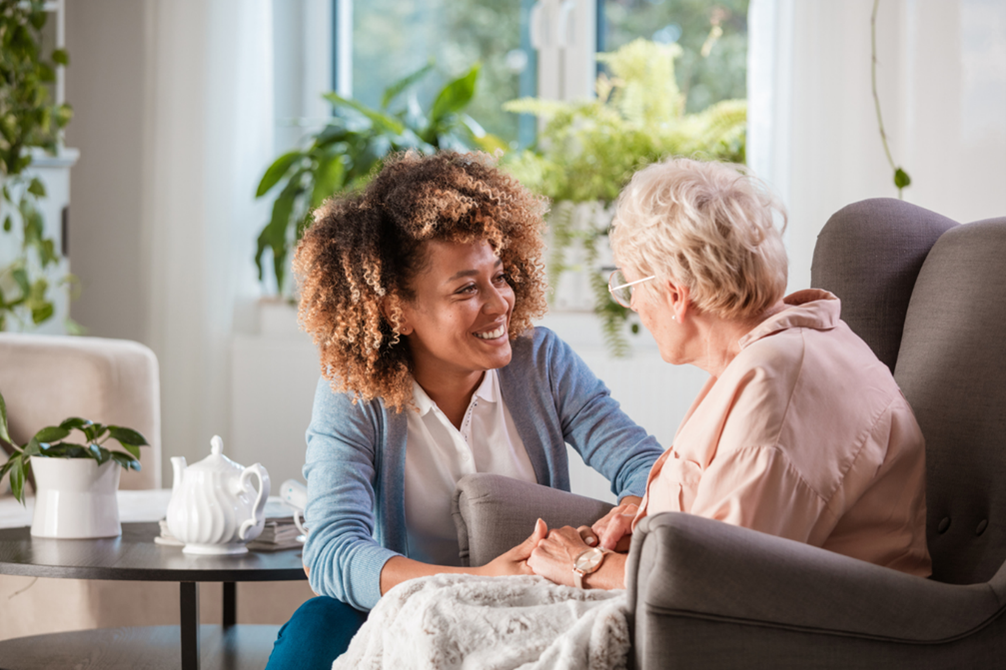 Caregiver speaking with senior in the comfort of their home.
